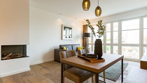 Un salon moderne avec une cheminée, une table à manger et un canapé.