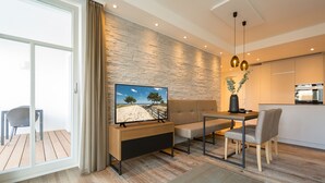 Un salon moderne avec un téléviseur, un canapé, une table à manger et des chaises.