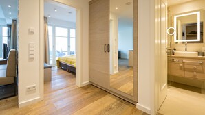 Une chambre à coucher moderne avec une grande armoire, une table de chevet et un lit.