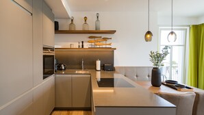 Una cocina moderna con electrodomésticos integrados, un comedor y vistas al exterior.
