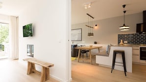Una cucina moderna con pavimento in legno, un'area pranzo con una panca e vista sull'esterno.
