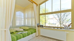 Ein Zimmer mit Bett, Fenster und Heizkörper.