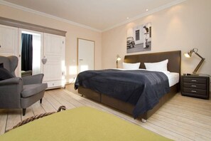 Une chambre à coucher comprenant un lit, une chaise, une table de chevet et une armoire.