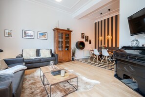Uma sala de estar moderna com sofá, mesa de centro e um espaço de refeições com cadeiras.