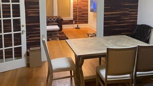 Un comedor con mesa y sillas de madera, un sofá y una lámpara.