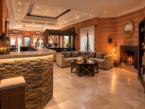 A spacious living area with a stone accent wall, a fireplace, and a seating area with a coffee table.