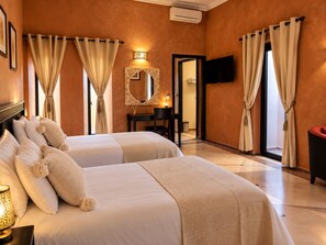 A hotel room with two beds, a desk, a chair, a TV, and a mirror. - Villa Malaa'ika for 20 people (Marrakech)