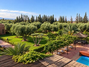 A landscaped garden with a pool, outdoor seating, and a gazebo.
