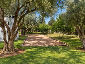 A well-maintained outdoor area with a dirt path leading to a covered seating area.