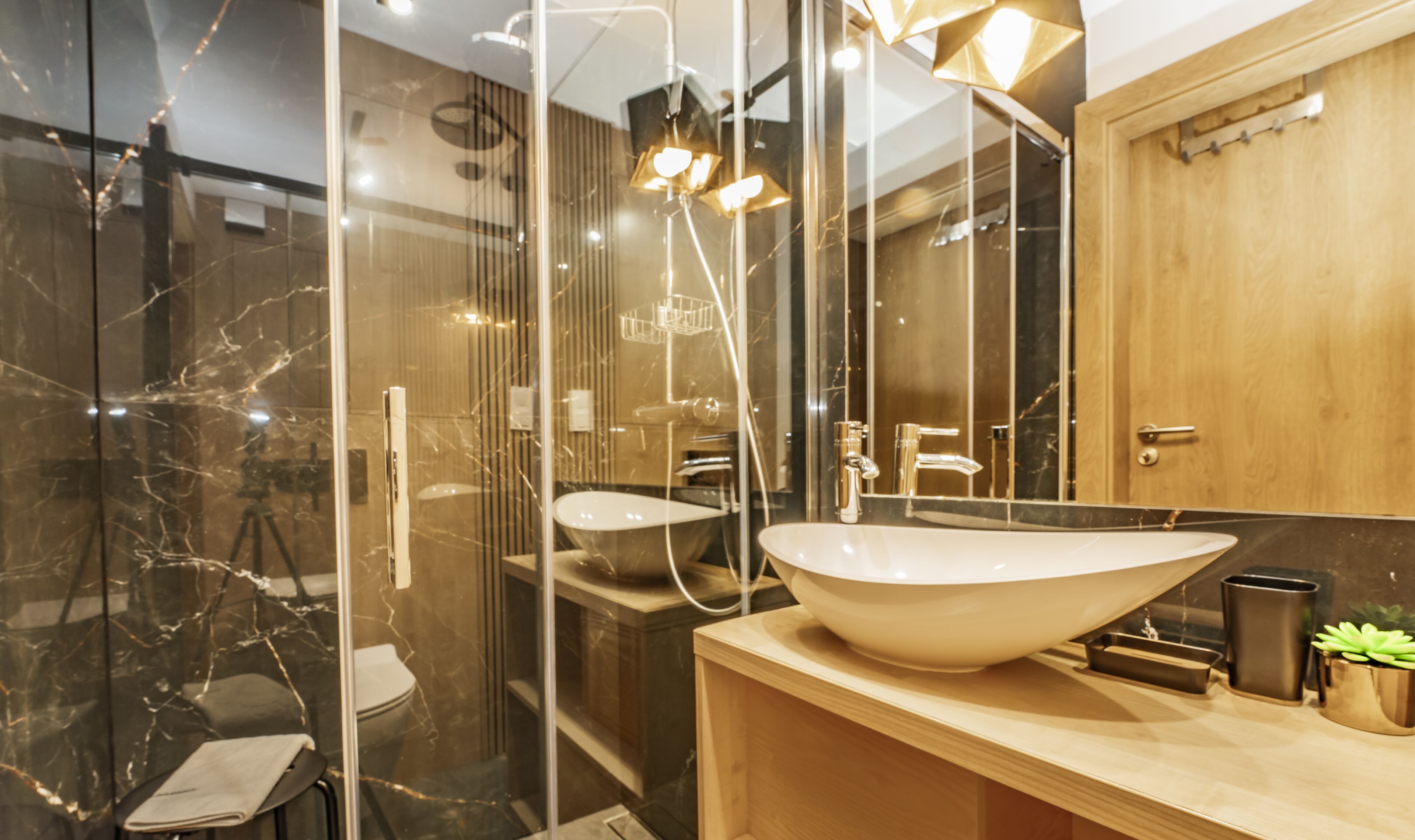 Ein modernes Badezimmer mit Duschkabine aus Glas, einem großzügigen Waschbecken und einer Holzwaschkommode.