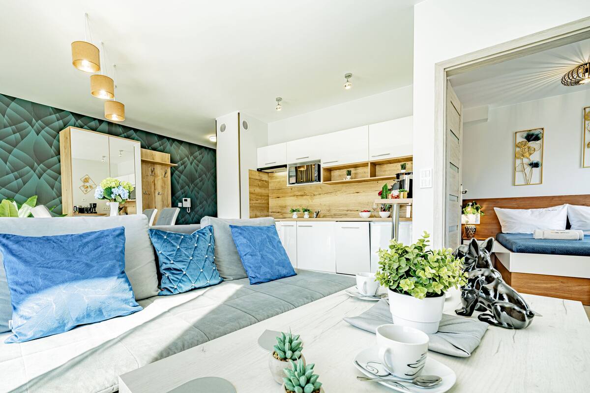 Een moderne woonkamer met een bank, eettafel en keukenhoek.