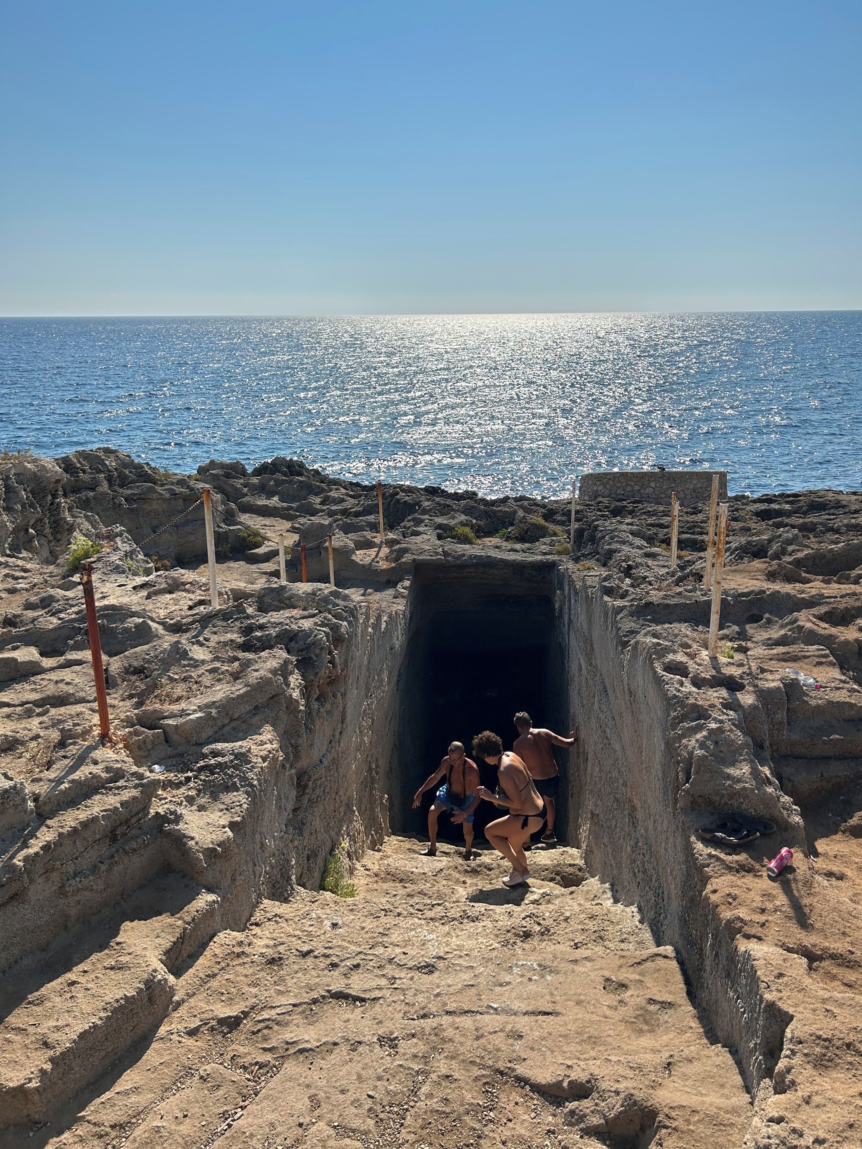 A cave entrance with a view of the sea.
