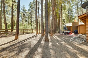 A cabin with a patio area, surrounded by tall trees. - 11 Mi to Rainbow Lake: Family Home w/ Large Yard (Pinetop)