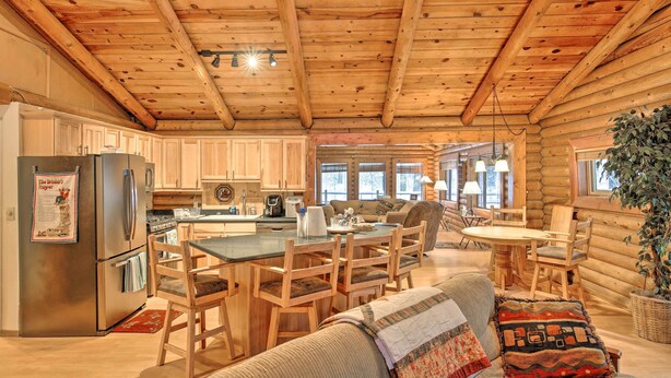 A log cabin interior with a kitchen, dining area, and living room. - 11 Mi to Rainbow Lake: Family Home w/ Large Yard (Pinetop)