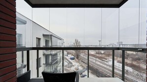 A balcony with a view of a modern building and railway tracks. - Stylish Apartment with Balcony | Parking | Close to the Oder River (Wroclaw)