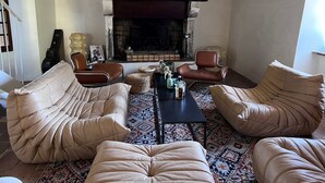 A living room with leather sofas, a coffee table, and a fireplace. - Village house with garden and pool (ANSOUIS)