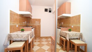 Une cuisine compacte dotée d’un îlot central, de meubles en bois et d’un pare-feu en carreaux.