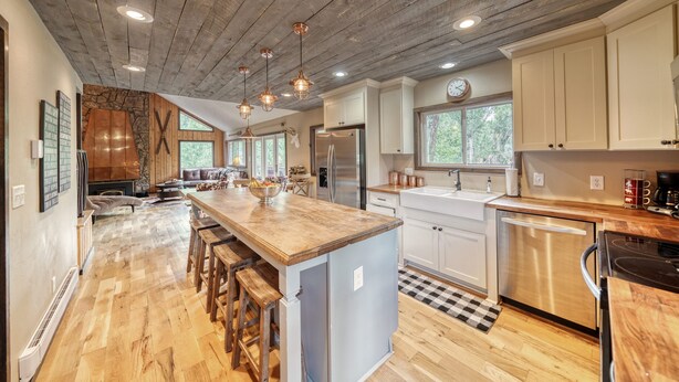 A spacious kitchen with a large island, wooden flooring, and modern appliances. - Gorgeous Rippling Waters!  Private Hot Tub- Spectacular Views! (Nathrop)