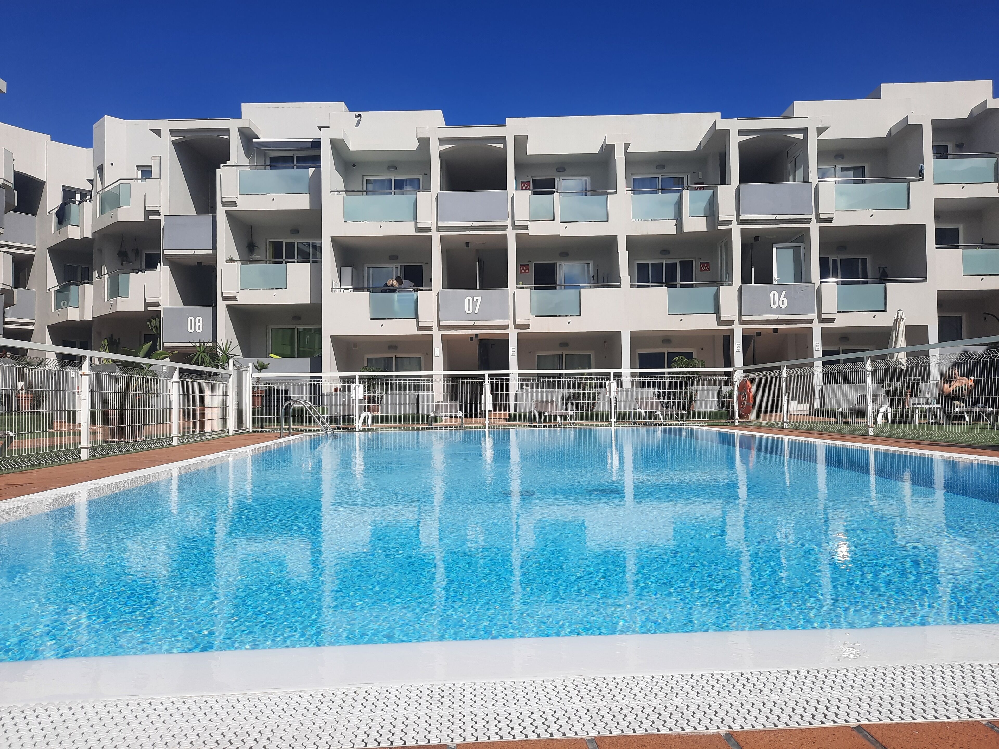 En moderne lejlighedsejendom med swimmingpool.