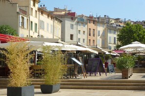 A courtyard with outdoor seating, potted plants, and a sign for 'La Maison du'. - Salon-de-Provence Villa Stay for 4 (Salon-de-Provence)