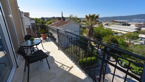 A balcony with a view of a cityscape, including buildings and a mountain in the distance. - D&D Apartments Tivat - Apartment with 4 beds - No.11 (Tivat)