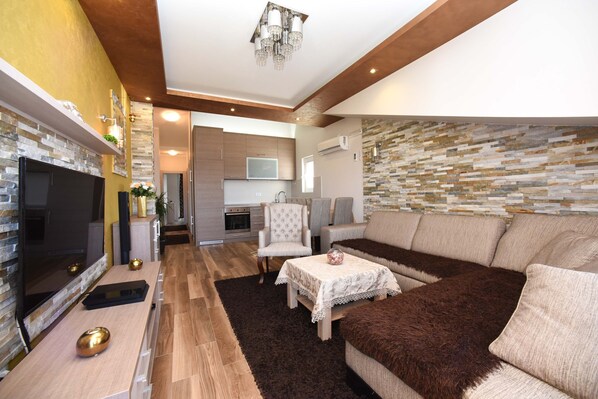 A modern living room with a fireplace, a sofa, and a dining area.