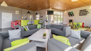 A modern living room with grey sofas, a white coffee table, and a wooden ceiling. - Holiday homes with pool, close to the beach (Sianozety)