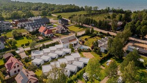 A residential area with multiple houses, a swimming pool, and a view of the sea. - Holiday homes with pool, close to the beach (Sianozety)