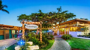 Un ristorante chiamato 'la pescadería' con posti a sedere all'aperto, un vialetto e un giardino curato.