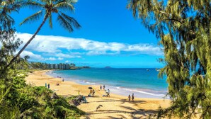 A beach with palm trees, clear blue sky, and ocean. - Maui Parkshore #412 Ocean View in the Heart of Kihei, Walk to Kamaole Beach (Kihei)