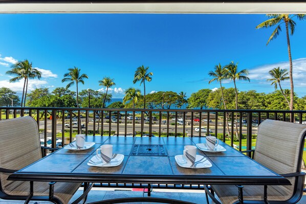 Mesa para dos con vista a palmeras y cielo despejado.