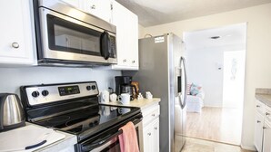 A modern kitchen with stainless steel appliances, a coffee maker, and a kettle. - Private heated pool. Shark teeth, close to beaches, downtown, shopping, biking… (Venice)