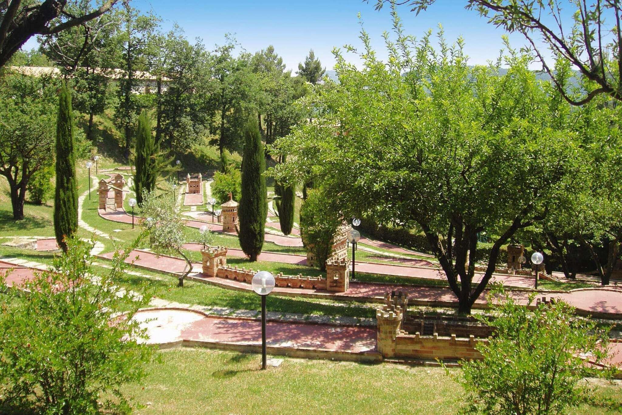 A landscaped garden with pathways, a fountain, and a gazebo.