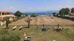 A coastal property with a grassy lawn, outdoor seating, and a view of the sea and mountains. - Summer Desire (Corfu)