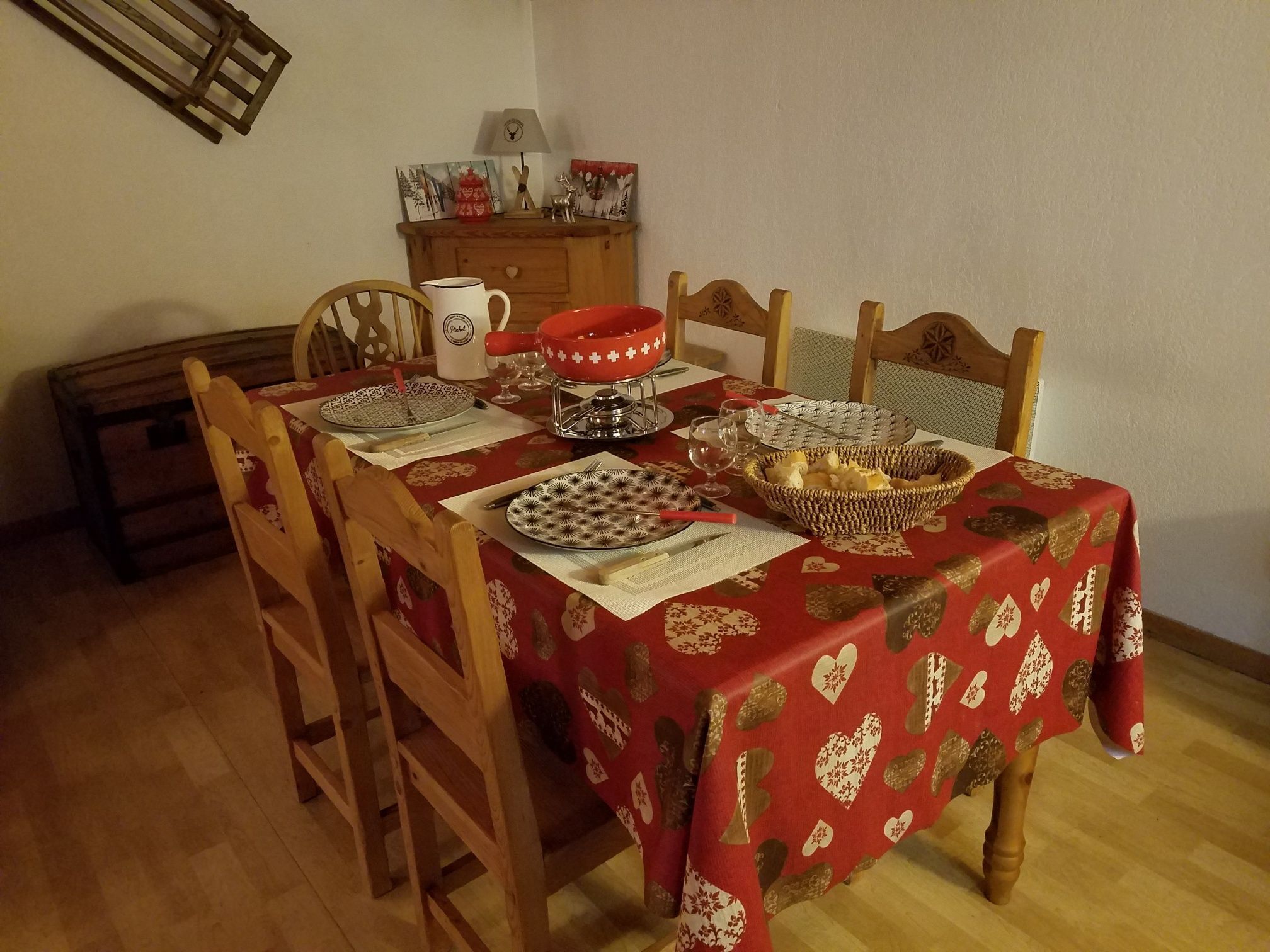 A dining table set with plates, bowls, and a red tablecloth.