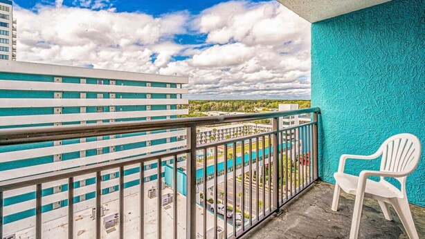 Un balcón con vistas a un edificio y un cielo despejado.