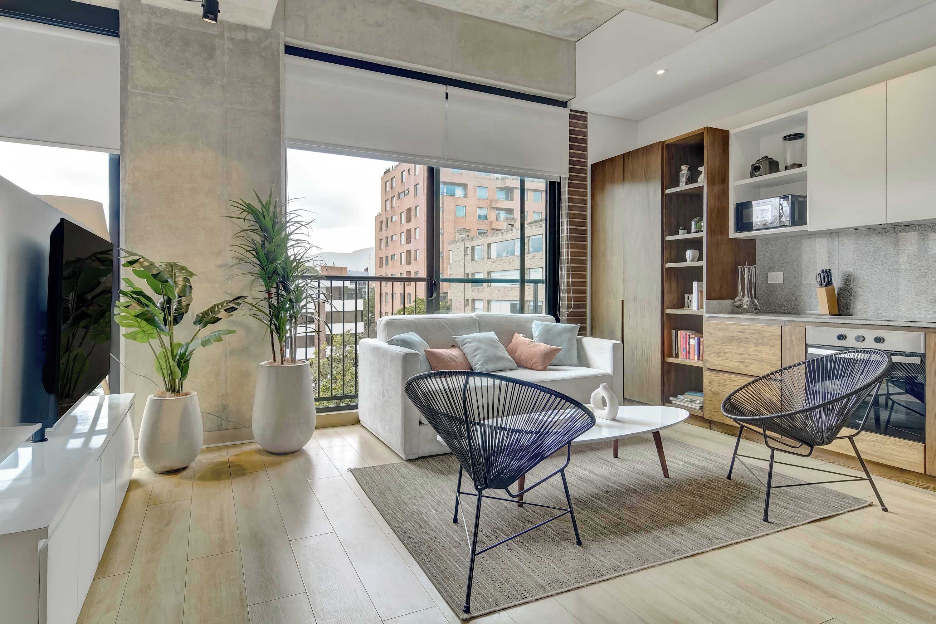 Un appartement moderne comprenant un espace de vie, une cuisine et un balcon.