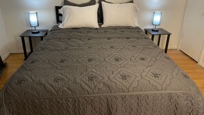 A neatly made bed with a patterned bedspread, two bedside lamps, and a headboard. - 11-Guests/Airport -Minute Away/Pet-Welcome/4-BDR/2-FBA/5-QBED! (Oklahoma City)