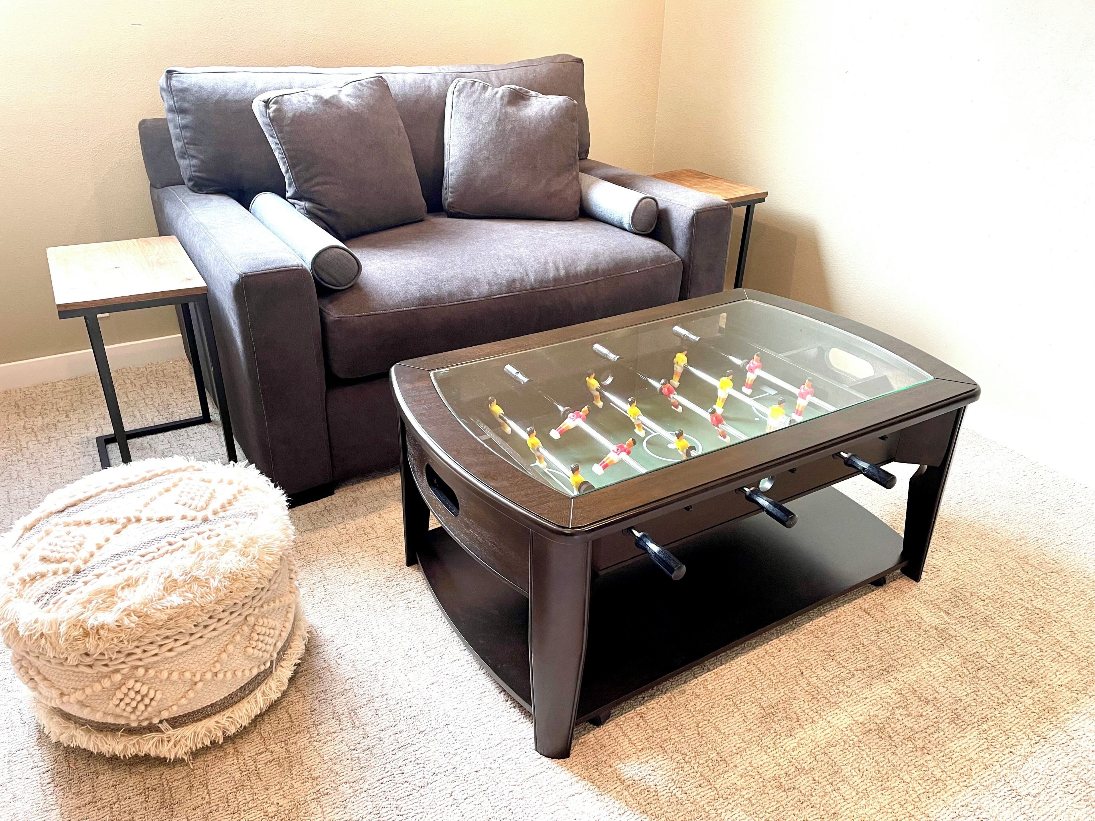 A living room with a sofa, a glass-top coffee table, and a small side table.