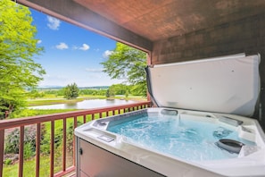 A hot tub on a balcony with a scenic view of a lake and trees. - The best sunset views are at Mountain View Retreat! (Canaan Valley)