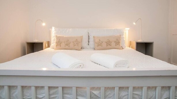 A neatly made bed with two pillows, two bedside tables, and a headboard. - Coal Miners Cottage - Moments to Seafront & Deal Town (Deal)