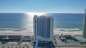 Um hotel alto com vista para o mar e a praia.