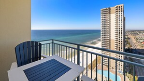 Een balkon met uitzicht op de oceaan en een hoog gebouw.