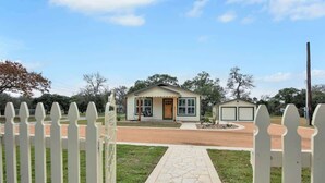 Eenlaagse woning met een veranda, een garage en een verharde oprit.