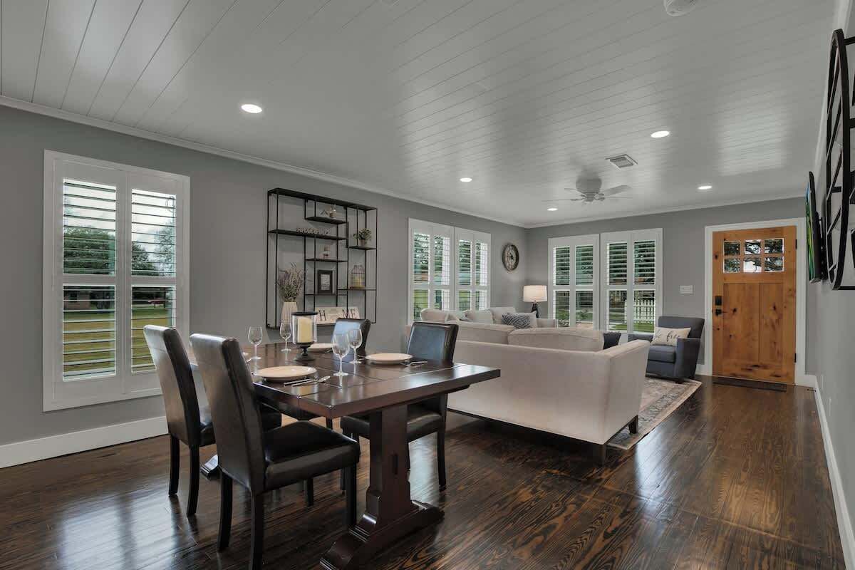 A spacious living area with a dining table, chairs, a sofa, and a coffee table.