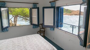 Une pièce avec un lit, une chaise et des fenêtres avec des rideaux.