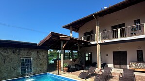 A swimming pool with lounge chairs and a stone wall.