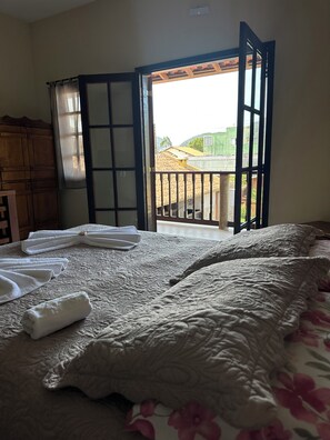 Una camera da letto con un letto, una finestra vista edifici e una porta.