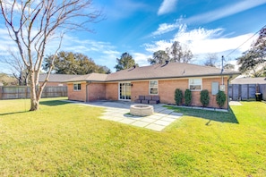 A single-story brick house with a patio, a fire pit, and a fenced yard. - Beautiful home in Houston Memorial, Galleria Area (Houston)