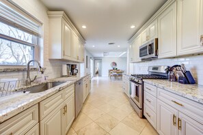 A spacious kitchen with white cabinetry, a granite countertop, and stainless steel appliances. - Beautiful home in Houston Memorial, Galleria Area (Houston)
